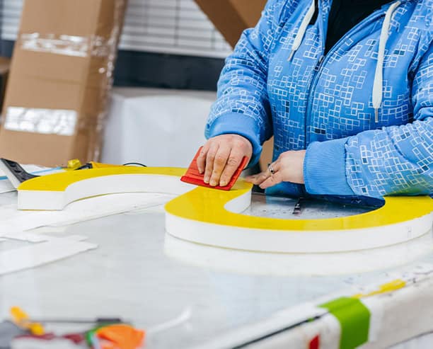 Worker Assembling Large Signage